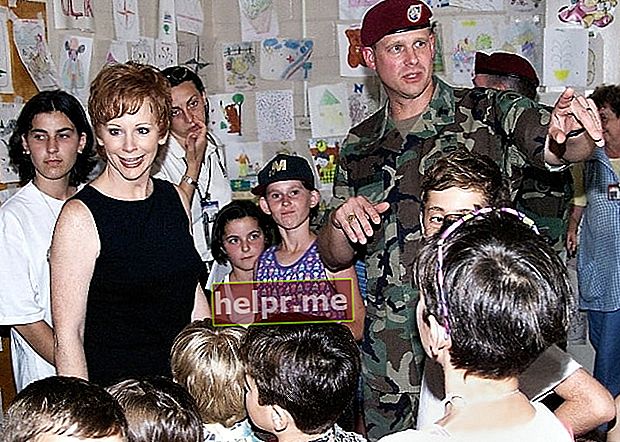 Reba McEntire (amb un vestit negre) amb refugiats de Kosovo el juny de 1999